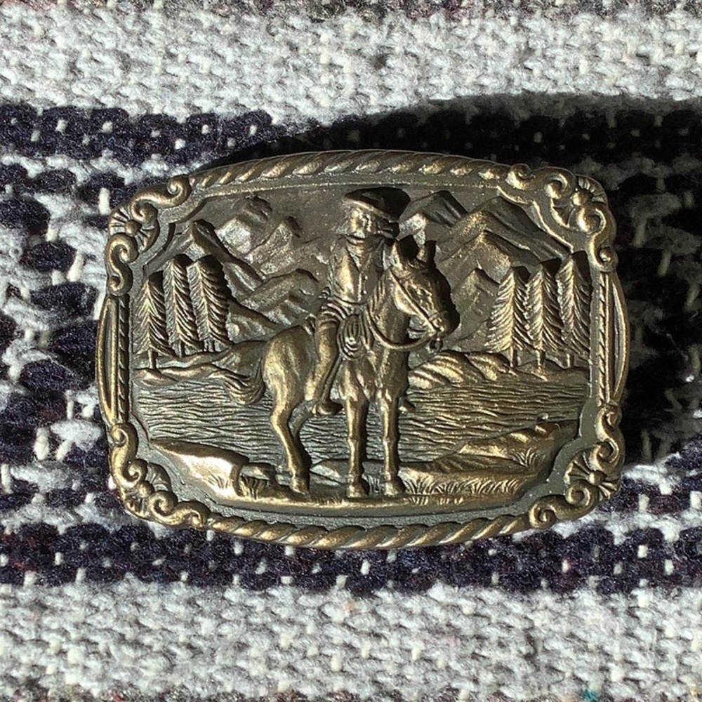 Vintage 1970’s  belt buckle with cowboy on a horse with trees & mountains
